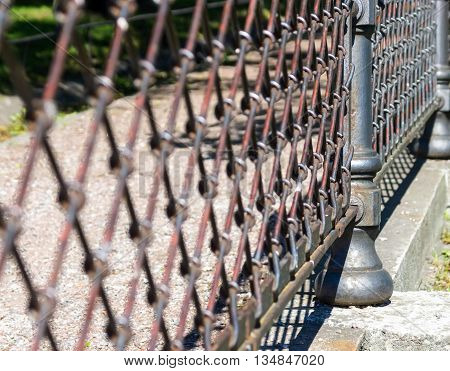 indistinct fragment of an old iron fence closeup in park in outdoor and a blank space