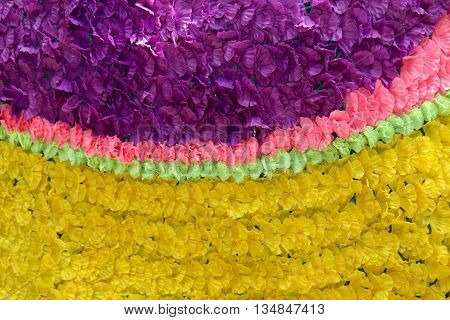 Background of colorful fake flowers that decorated the backdrop.