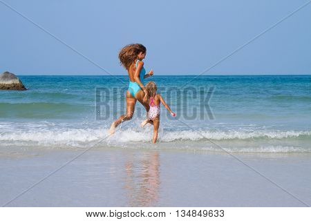 Mum with daughter on the beach in Thailand