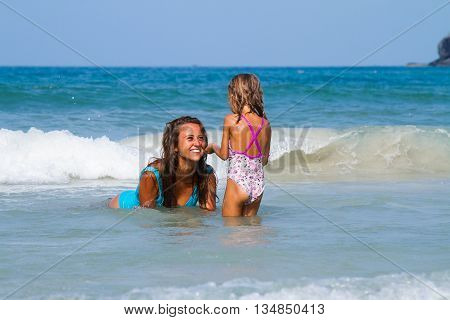 Mum with daughter on the beach in Thailand