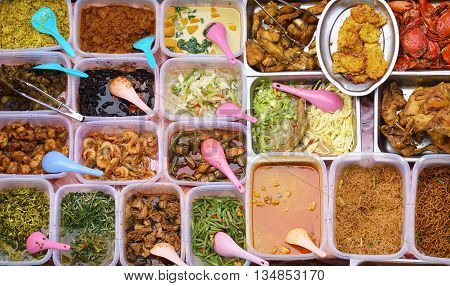 Variety of delicious Malaysian home cooked dishes sold at street market stall in Kota Kinabalu Sabah from top angle view.