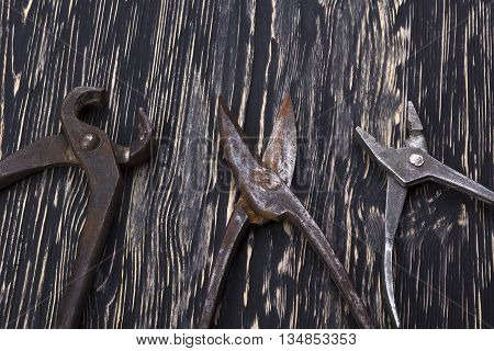 Heap of old instruments on wooden background. Pliers and scissors on wooden background.