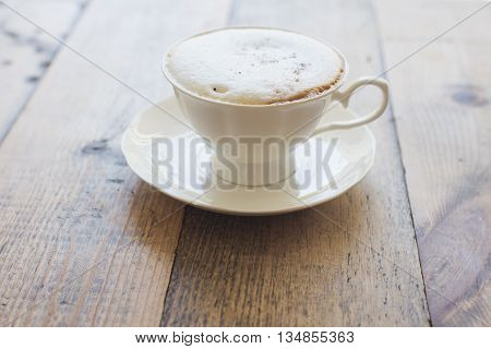 Beautiful hot cappuccino on wooden table background