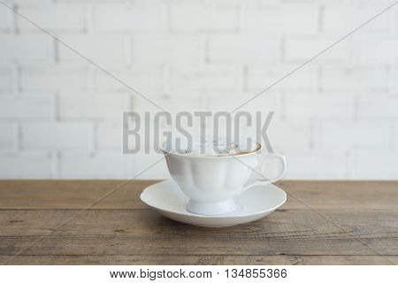 Beautiful hot cappuccino on wooden table background