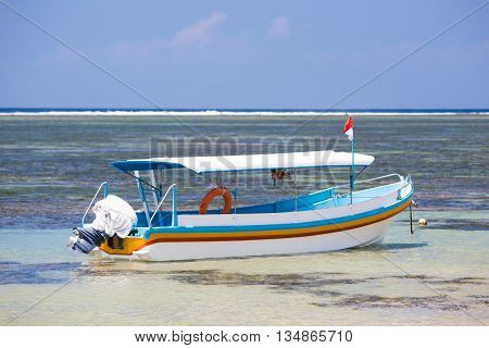 A Balinese fishing boat moored on a Sanur beach in Bali, Indonesia