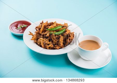 Crispy onion bhaji or kanda bhaji or fried onion pakore or pakode, delicious street food, favourite indian snack in monsoon served with hot tea