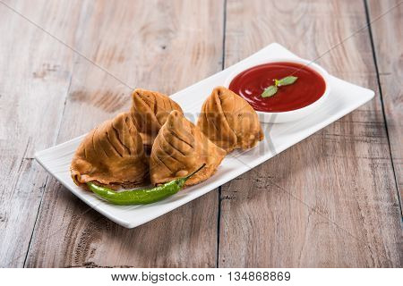 Samosa snack with tomato ketchup and hot tea, Fresh samosas with ketchup and hot chai ready for breakfast