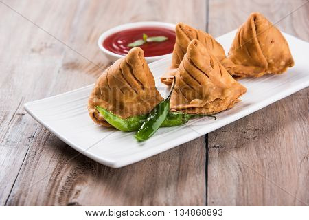 Samosa snack with tomato ketchup and hot tea, Fresh samosas with ketchup and hot chai ready for breakfast