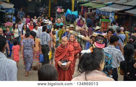 Kyaiktiyo Mon state Myanmar - April 24 2016: Buddhist Monks stand still among crowd in Kyaiktiyo temple