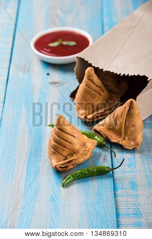 Samosa snack with tomato ketchup and hot tea, Fresh samosas with ketchup and hot chai ready for breakfast