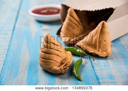 Samosa snack with tomato ketchup and hot tea, Fresh samosas with ketchup and hot chai ready for breakfast
