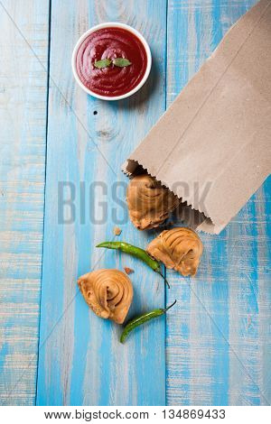 Samosa snack with tomato ketchup and hot tea, Fresh samosas with ketchup and hot chai ready for breakfast