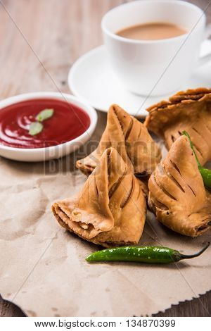 Samosa snack with tomato ketchup and hot tea, Fresh samosas with ketchup and hot chai ready for breakfast