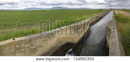 Hugh irrigation canal flows over the fertile meadows of High Guadiana or Vegas Altas Extremadura Spain. Panoramic shot