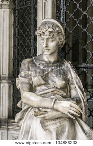 Statue of a grieving girl on monumental cemetery of Staglieno in Genoa.