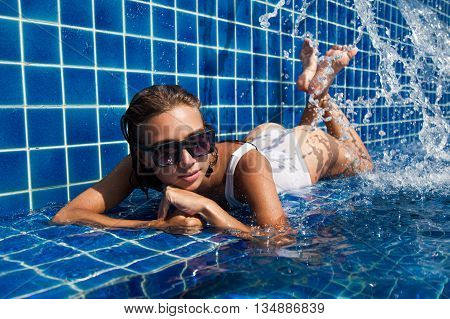 Woman in blue pool in white swimwear