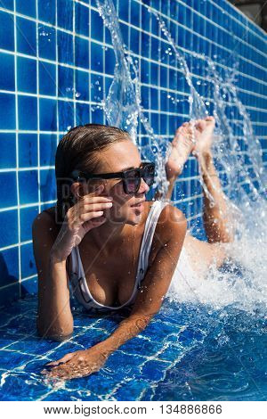 Woman in blue pool in white swimwear