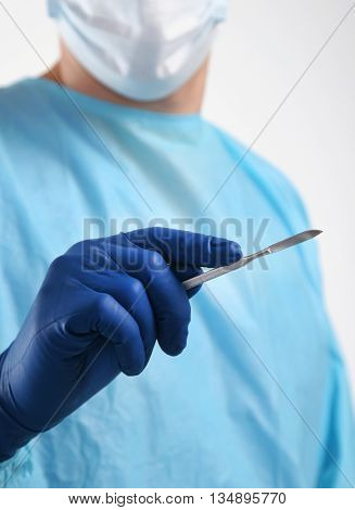 Man surgeon holds a scalpel. clinic tool