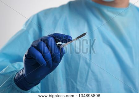 Man surgeon holds a scalpel. clinic tool