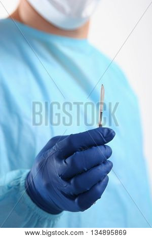 Man surgeon holds a scalpel. clinic tool