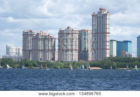 Urban landscape with modern houses and surfboards on a river bay