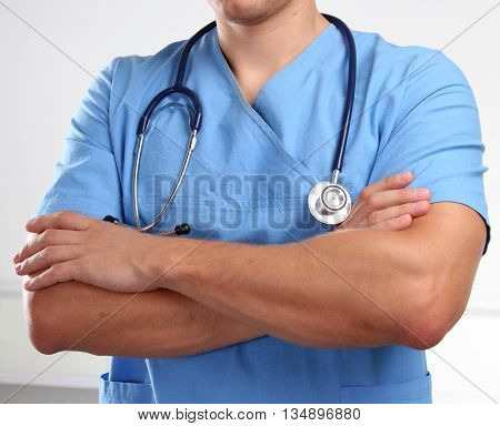 Doctor in blue uniform holding X-rays. clinic