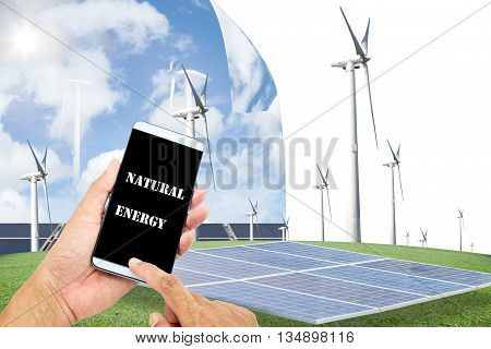 man using mobile smart phone control with Solar panelswind turbines on green grass with blue sky backgroundnatural Energy concept