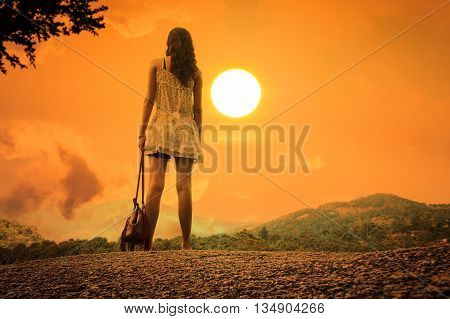 Beautiful women standing on the stone at mountain sunset background