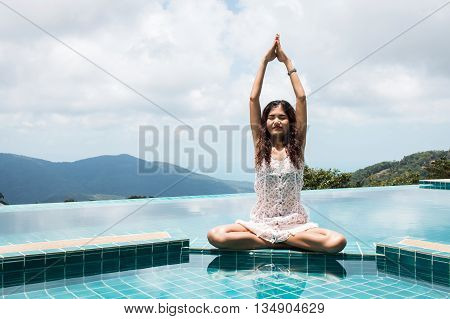 Young woman practicing yoga on natural background