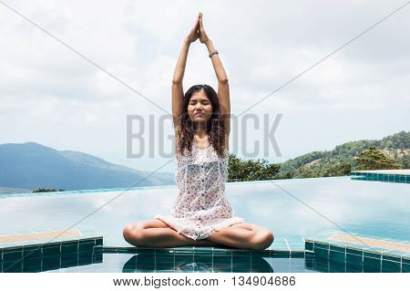 Young woman practicing yoga on natural background