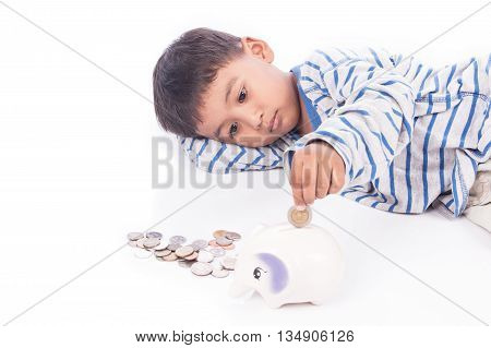 cute asian boy saving money in piggy bank