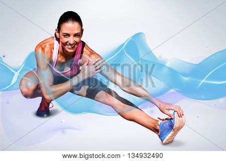 Portrait of happy sportswoman is stretching her muscle against grey background