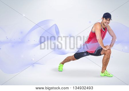 Portrait of male athlete doing stretching exercise against grey background