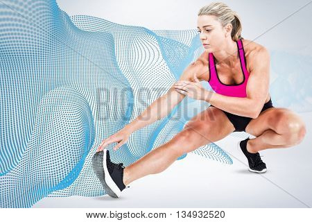 Female athlete stretching against grey background