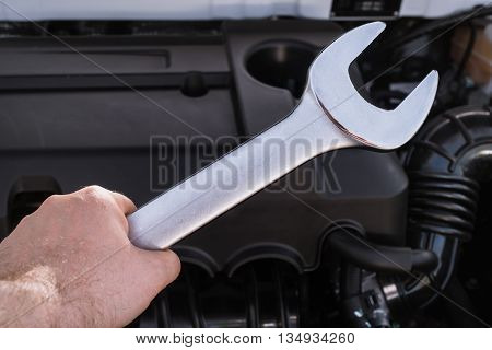 Wrench in hand over the internal combustion engine