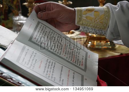 VOYUTYN UKRAINE - JANUARY 08 - Priest reading from the holy bible in Voyutyn on January 08 2009. Shallow depth of fielf.