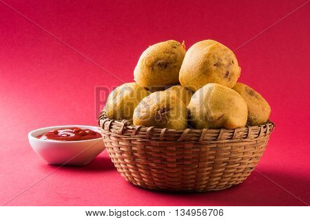batata vada or aalu bonda or aalu bonde, a tasty indian snacks, served with tomato ketchup or green chilli and onion