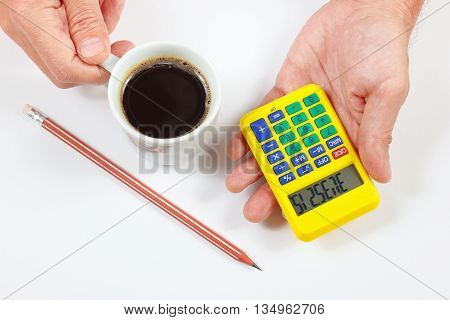 Hands holding a digital calculator and cup of coffee on a white background