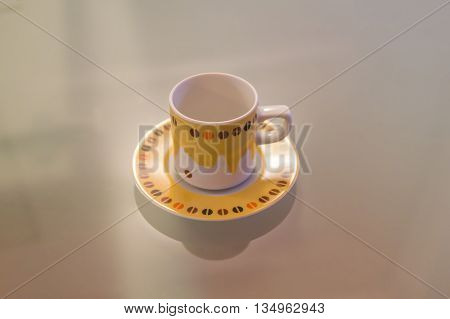Yellow and white coffee cup decorated over a modern table