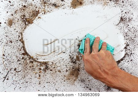 Hand with rag wiping a very dirty surface