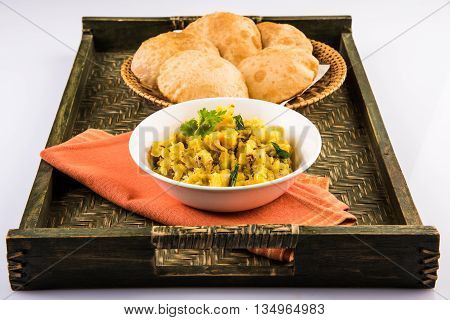 indian semi dry potato spicy recipe also known as aalu bhaji or aalu sabji served with indian puri or poori