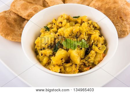 indian semi dry potato spicy recipe also known as aalu bhaji or aalu sabji served with indian puri or poori