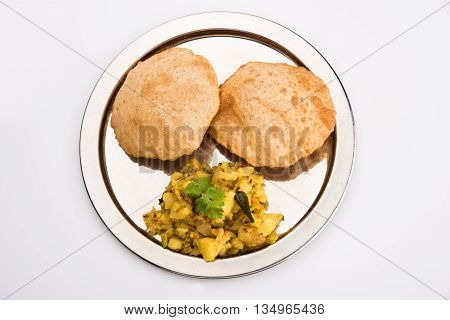 indian semi dry potato spicy recipe also known as aalu bhaji or aalu sabji served with indian puri or poori