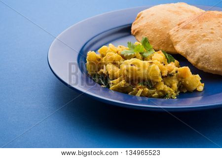 indian semi dry potato spicy recipe also known as aalu bhaji or aalu sabji served with indian puri or poori