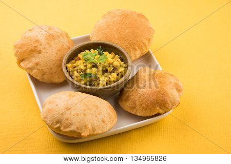 indian semi dry potato spicy recipe also known as aalu bhaji or aalu sabji served with indian puri or poori