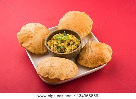 indian semi dry potato spicy recipe also known as aalu bhaji or aalu sabji served with indian puri or poori