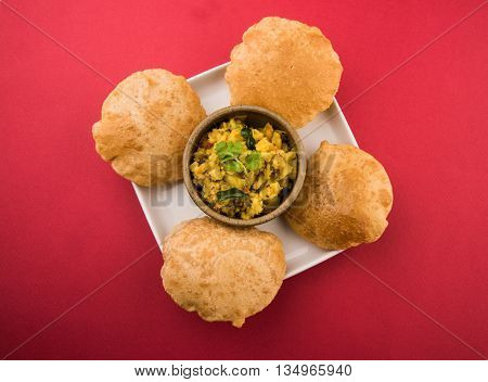 indian semi dry potato spicy recipe also known as aalu bhaji or aalu sabji served with indian puri or poori