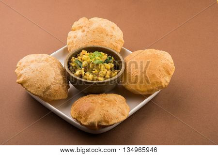 indian semi dry potato spicy recipe also known as aalu bhaji or aalu sabji served with indian puri or poori