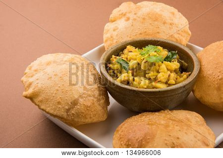 indian semi dry potato spicy recipe also known as aalu bhaji or aalu sabji served with indian puri or poori