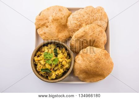 indian semi dry potato spicy recipe also known as aalu bhaji or aalu sabji served with indian puri or poori